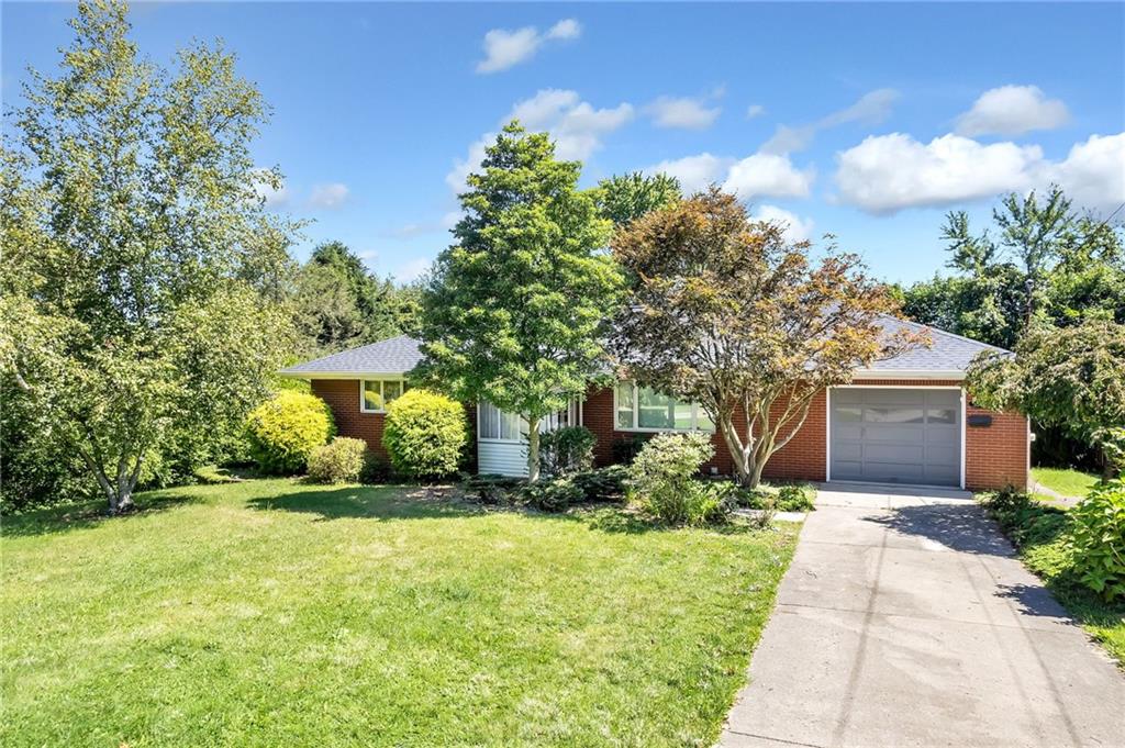 a front view of a house with a yard and trees