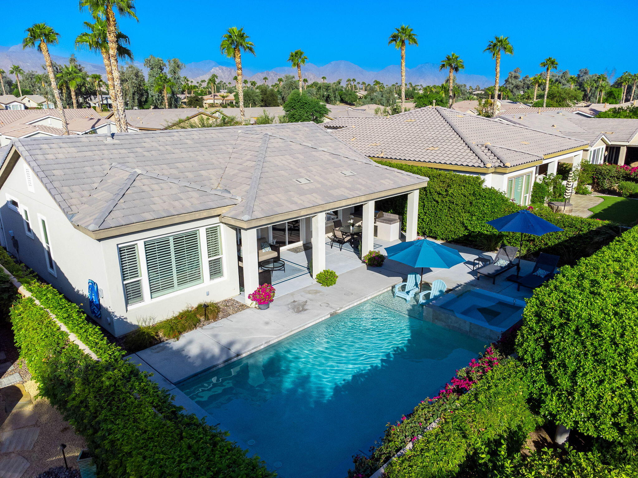 an aerial view of a house with swimming pool and outdoor seating