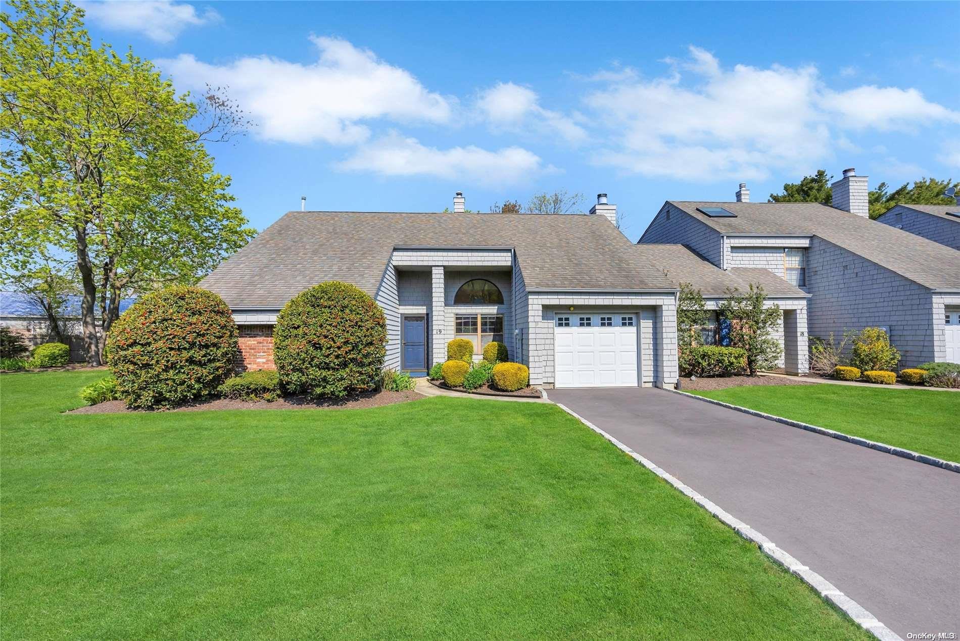 a front view of a house with a garden and yard