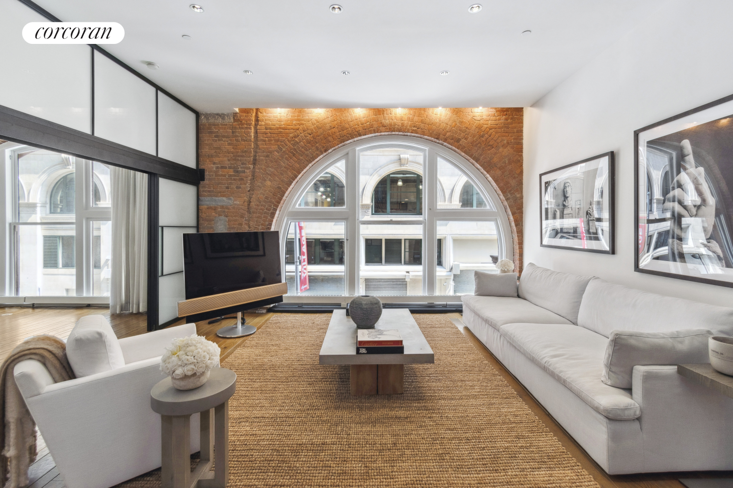 a living room with furniture a flat screen tv and kitchen view