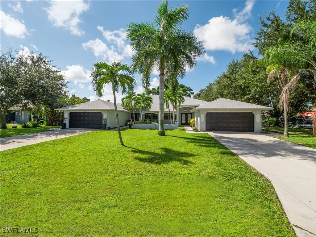 a view of a house with a backyard and a tree