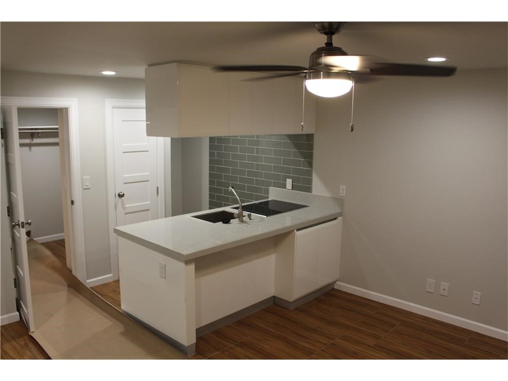 a kitchen with a sink cabinets and wooden floor