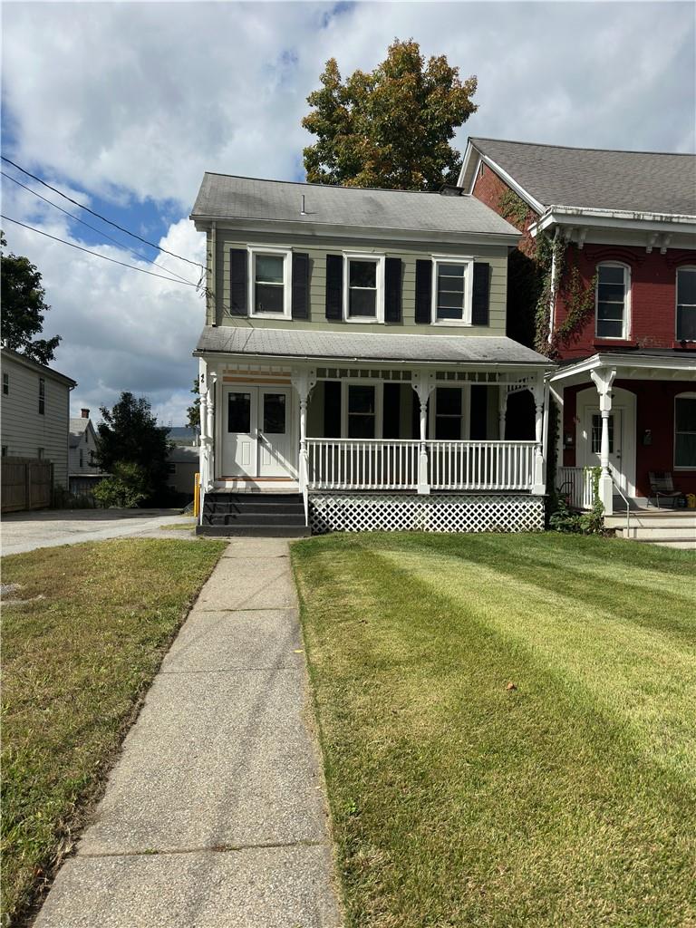 View of front of home featuring a front yard and a porch