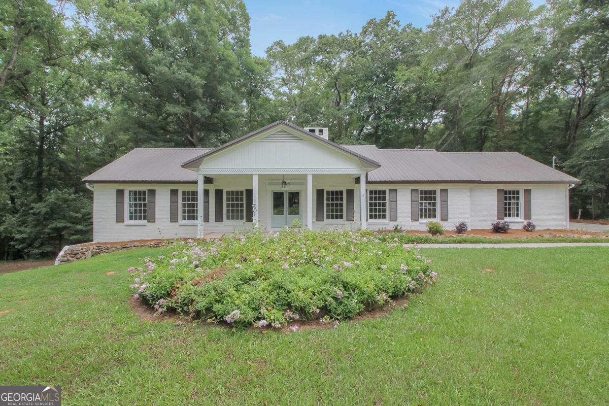 a front view of a house with a garden