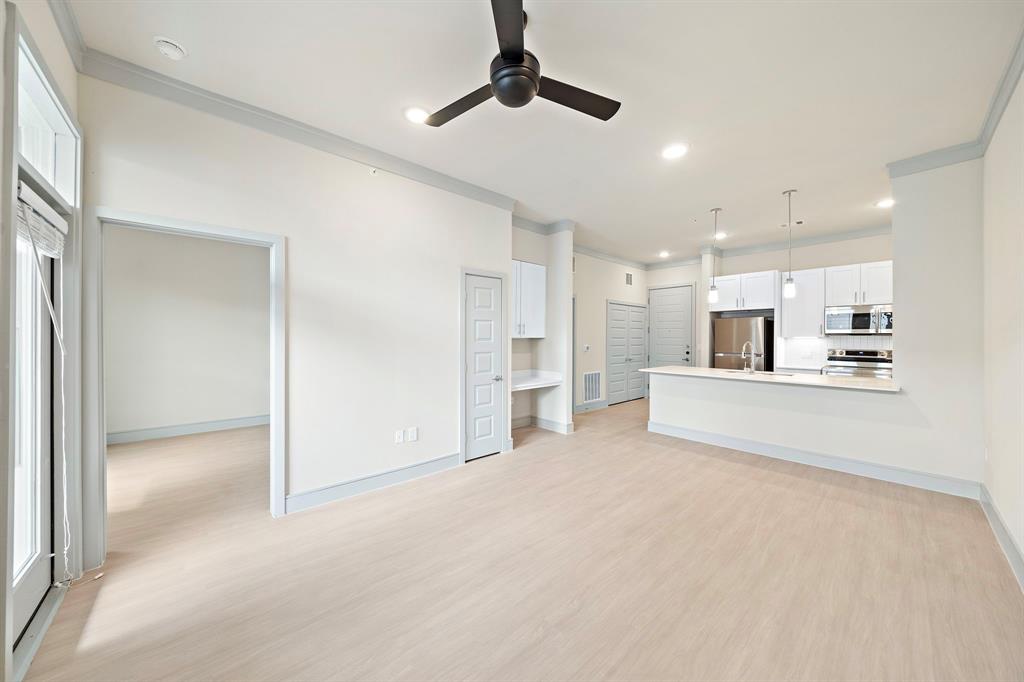 a view of a kitchen with kitchen island and stainless steel appliances