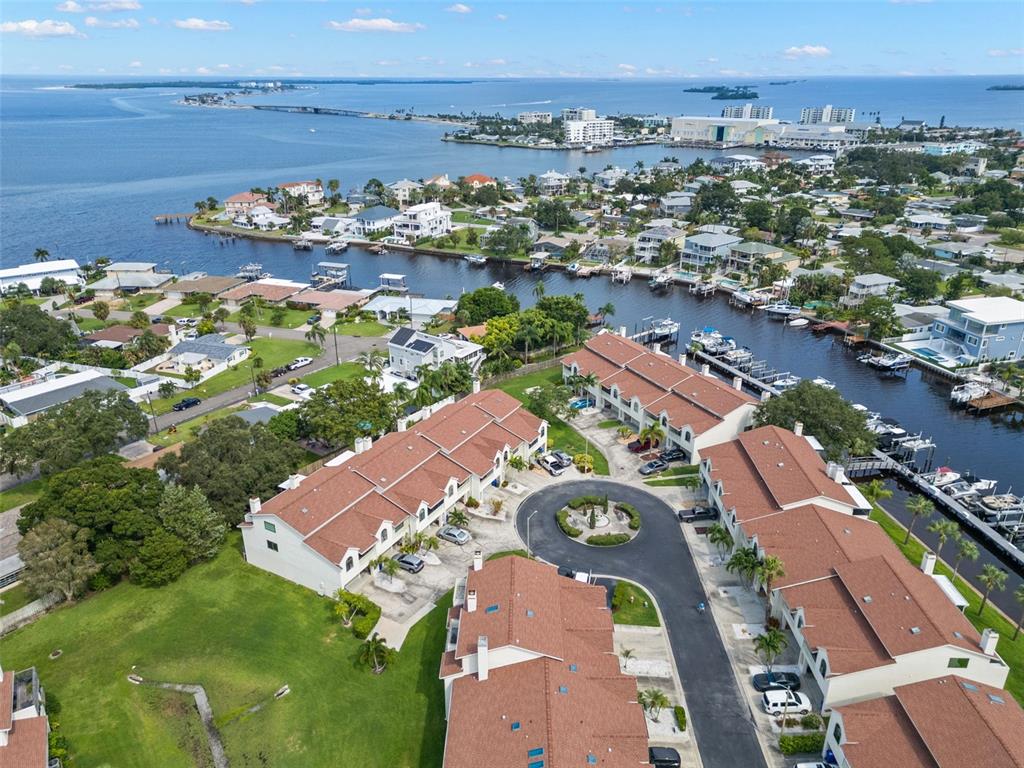 an aerial view of a city with lots of residential buildings ocean and mountain view in back