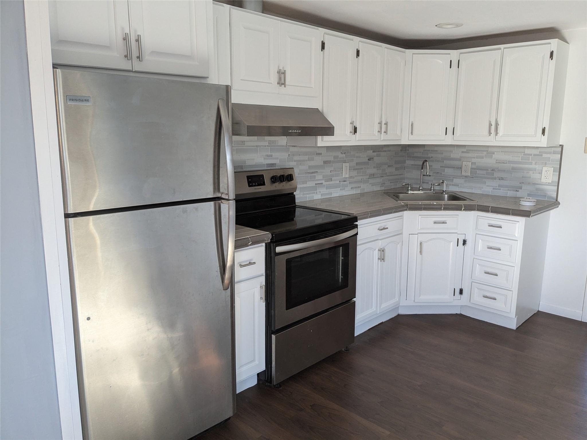 a kitchen with white cabinets and white stainless steel appliances