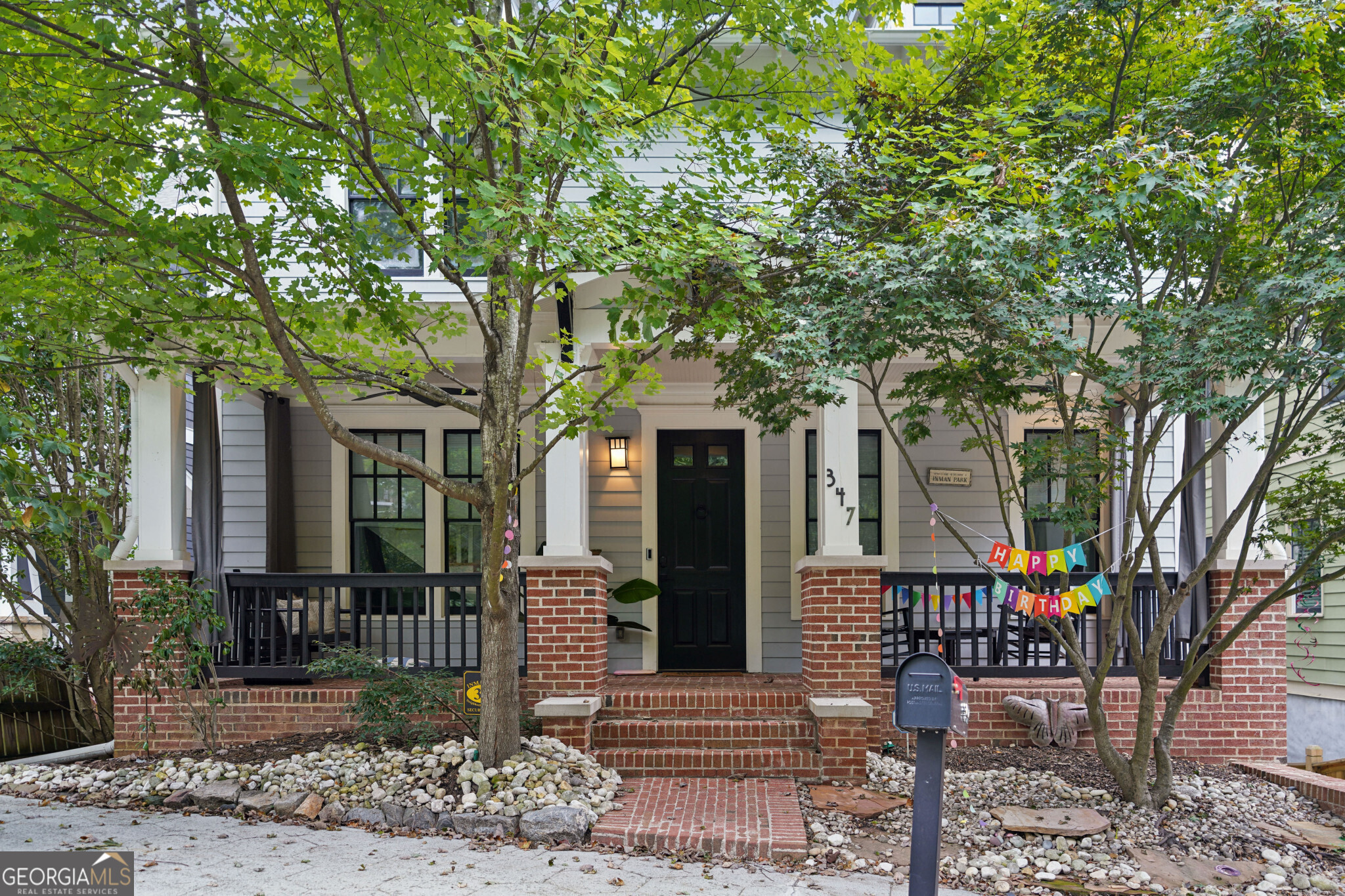 a front view of a house with a tree