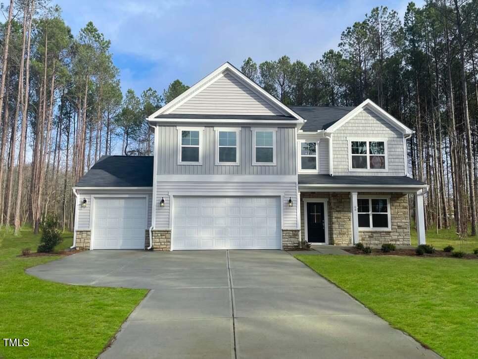 a front view of a house with a yard and trees