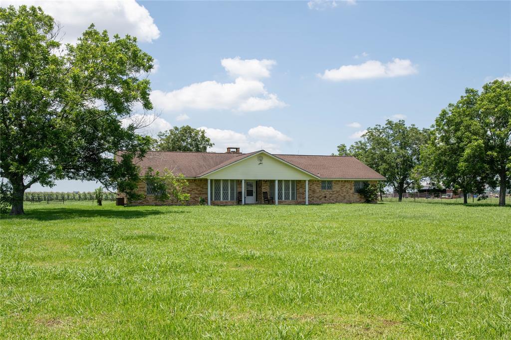 a front view of a house with a yard and trees