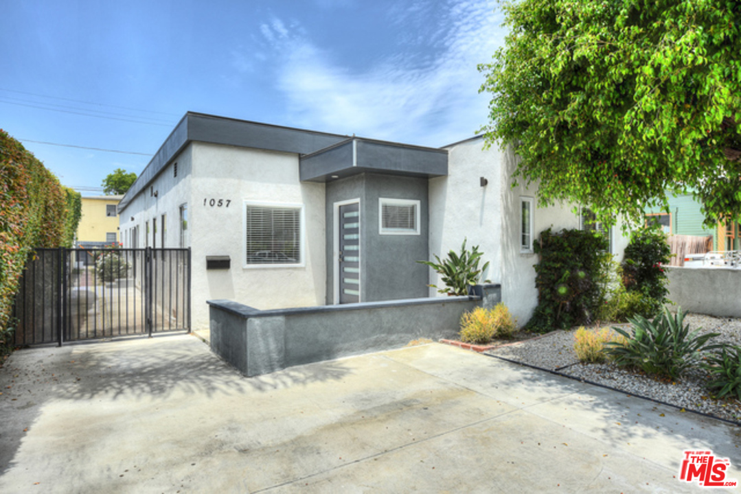 a front view of a house with a yard and potted plants