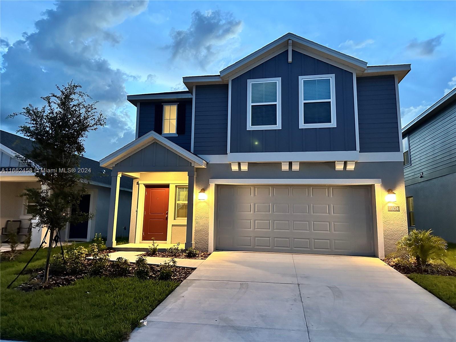 a front view of a house with a yard and garage