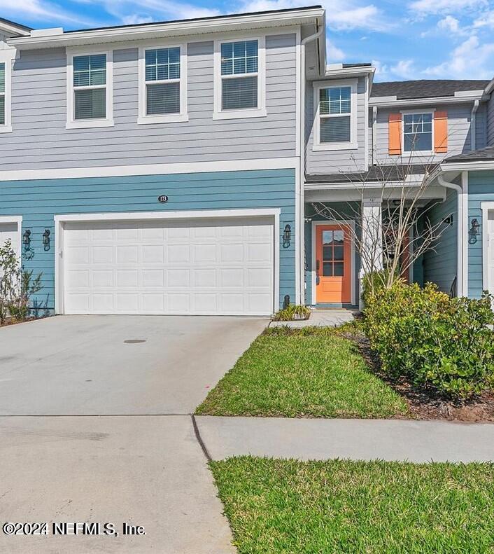 a view of a house with a yard and garage