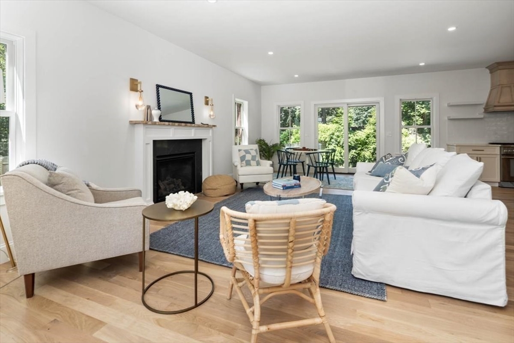 a living room with furniture a fireplace and wooden floor