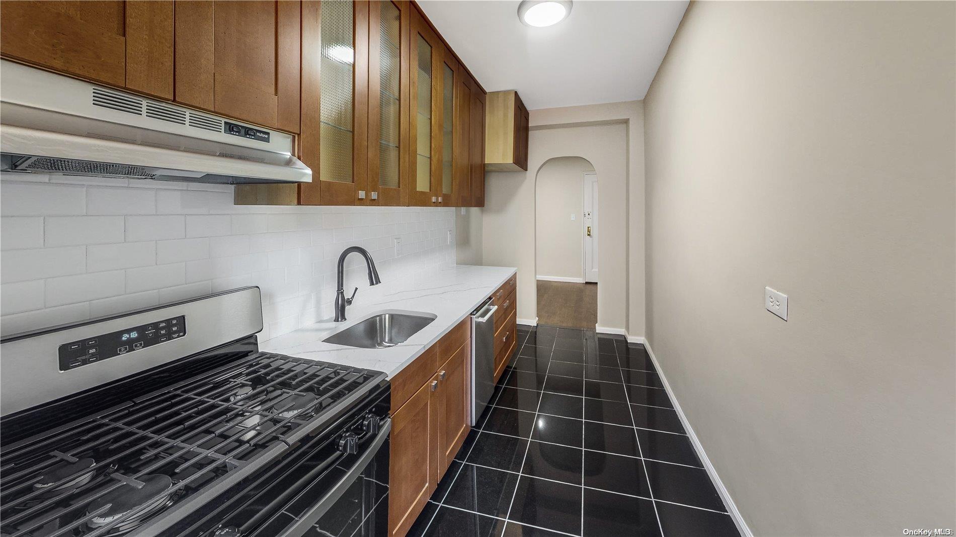 a close view of a sink a stove and cabinets