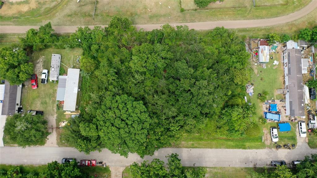 an aerial view of residential houses with outdoor space and trees all around