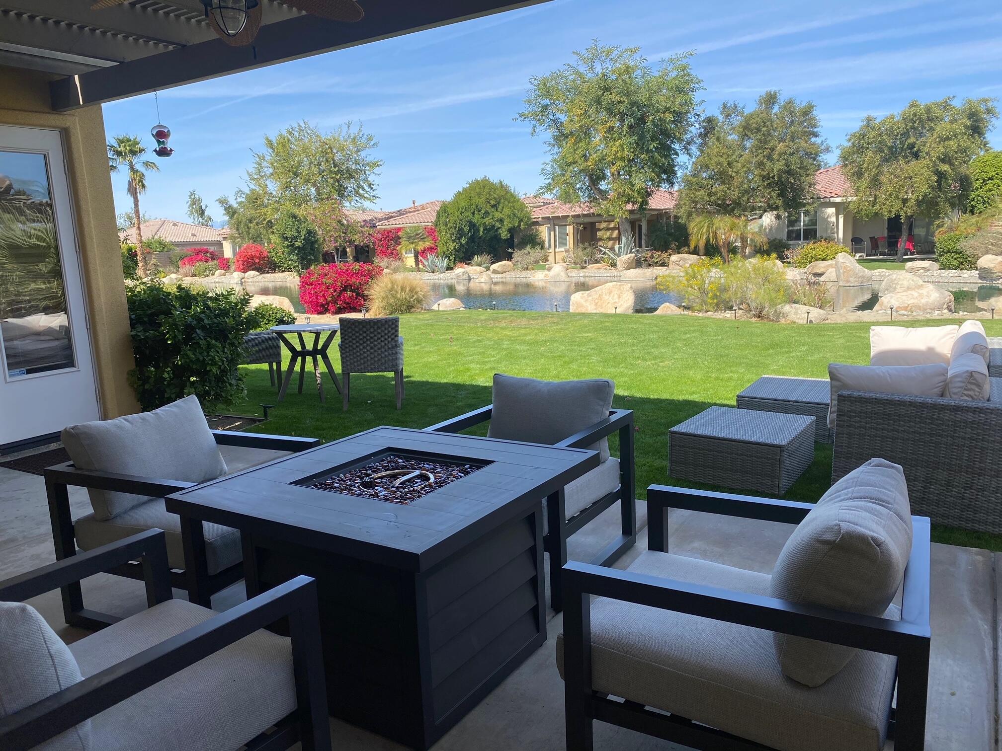 a view of a chairs and table in patio with a yard