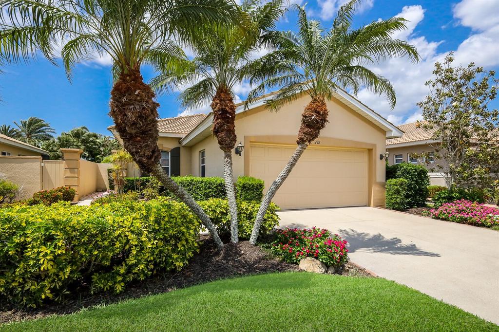 a view of a house with a yard and palm trees