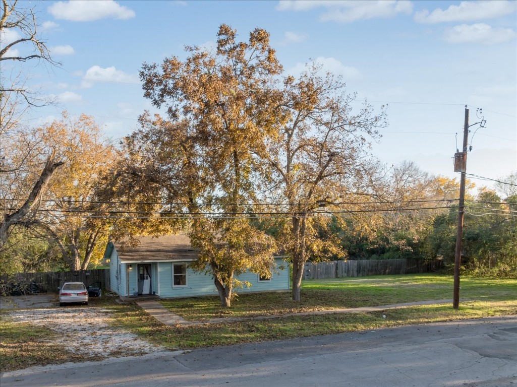 a view of a house with a big yard and large trees