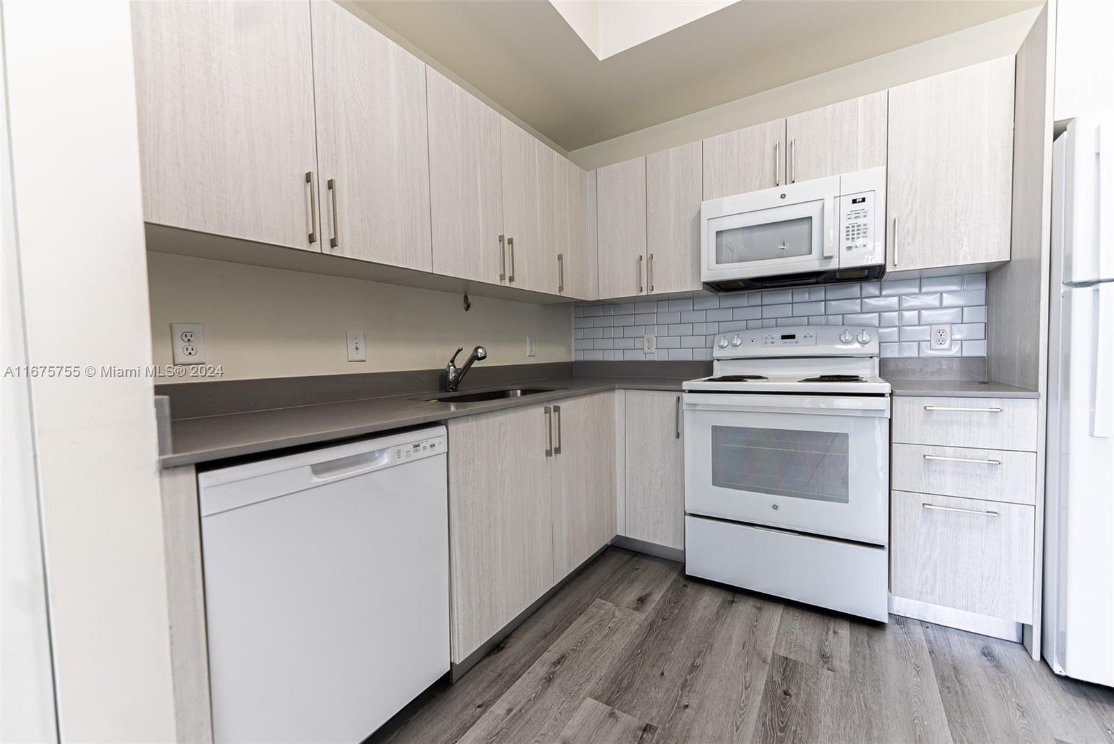 a kitchen with white cabinets and white appliances