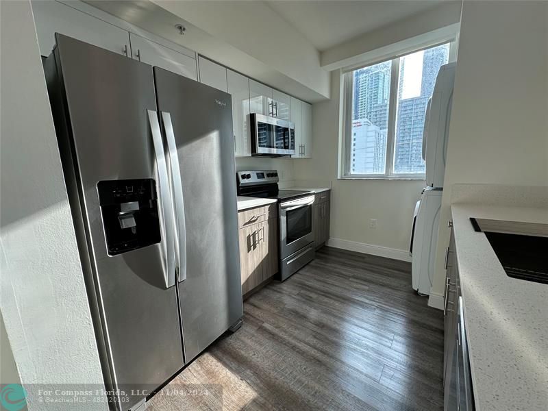 a kitchen with stainless steel appliances a refrigerator sink and microwave