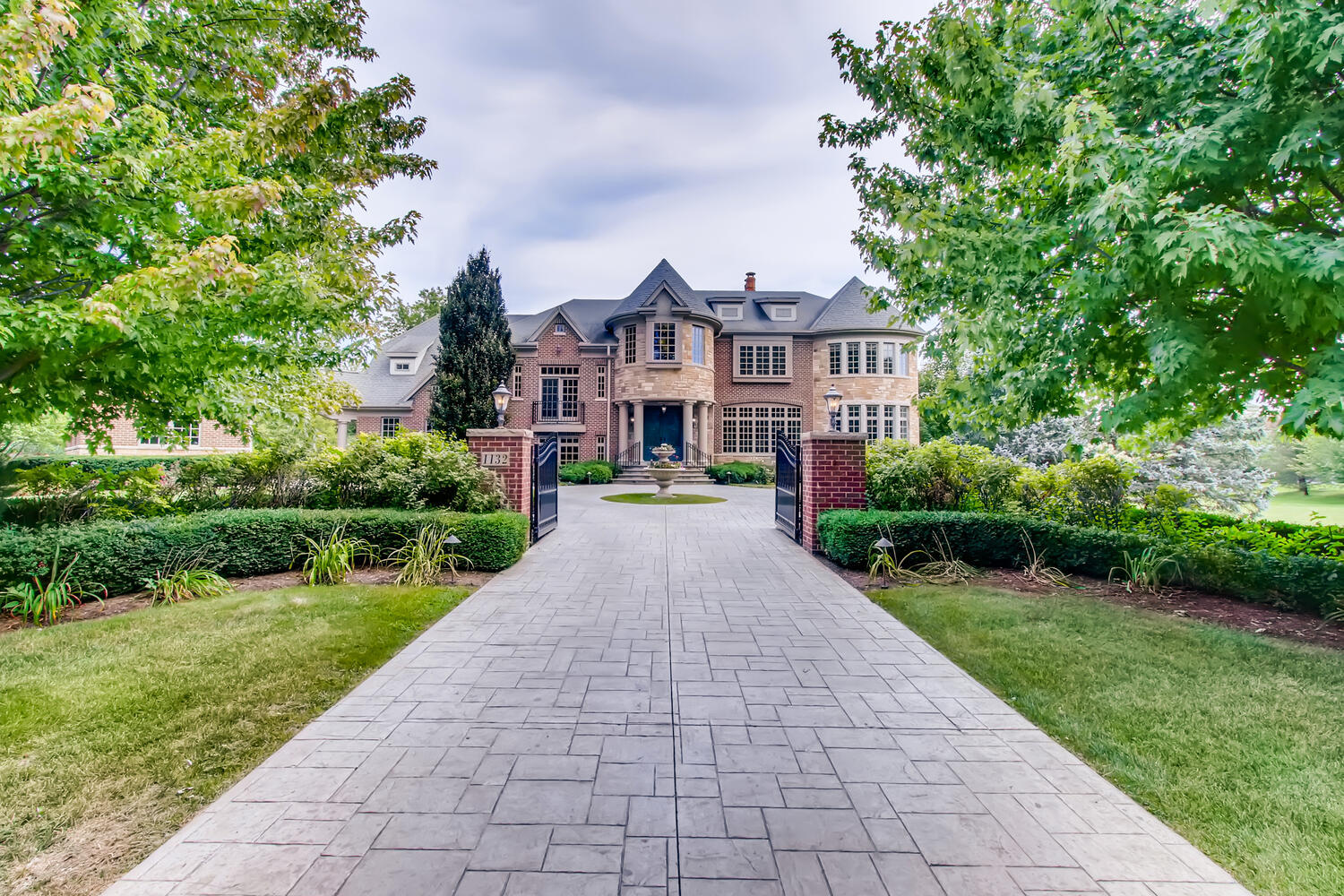 a front view of a house with a yard and potted plants