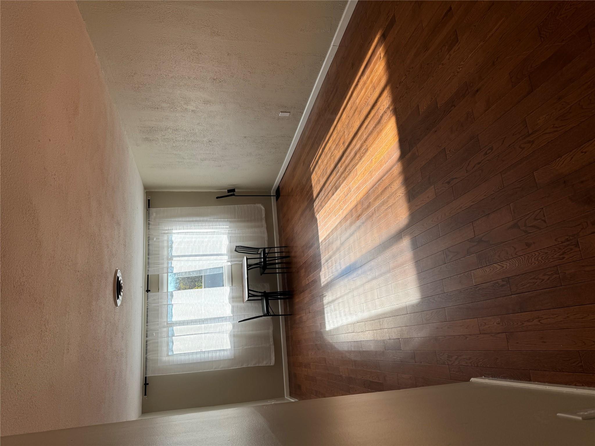 Spare room featuring a textured ceiling and dark hardwood / wood-style floors