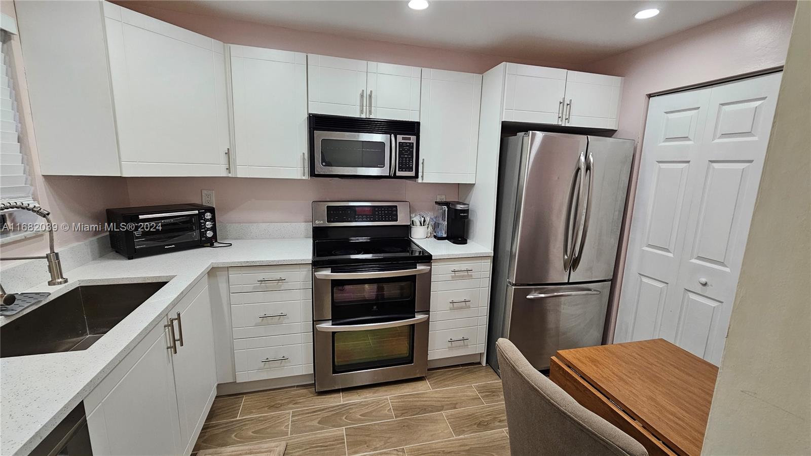 a kitchen with white cabinets and stainless steel appliances