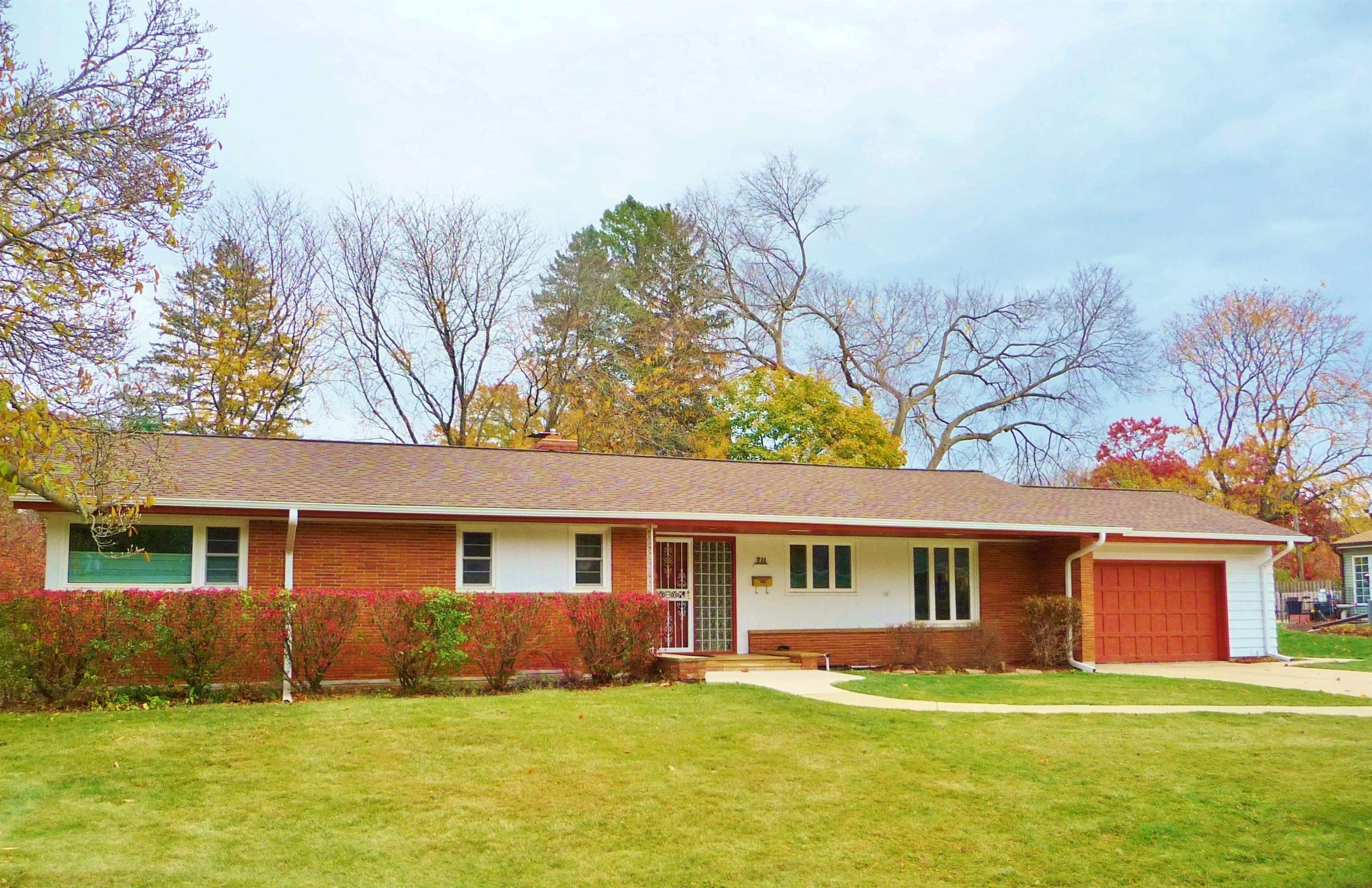 a front view of a house with a yard and trees