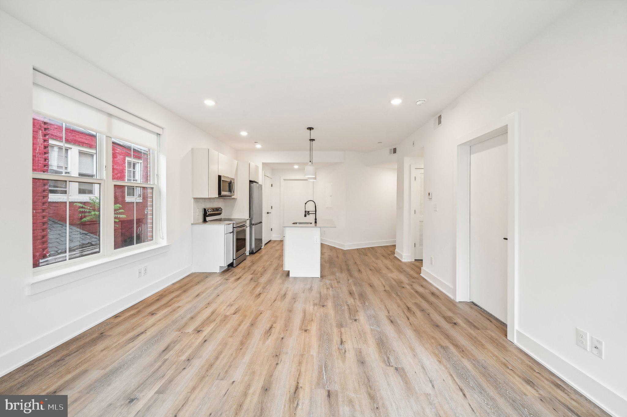 a view of empty room with wooden floor and windows