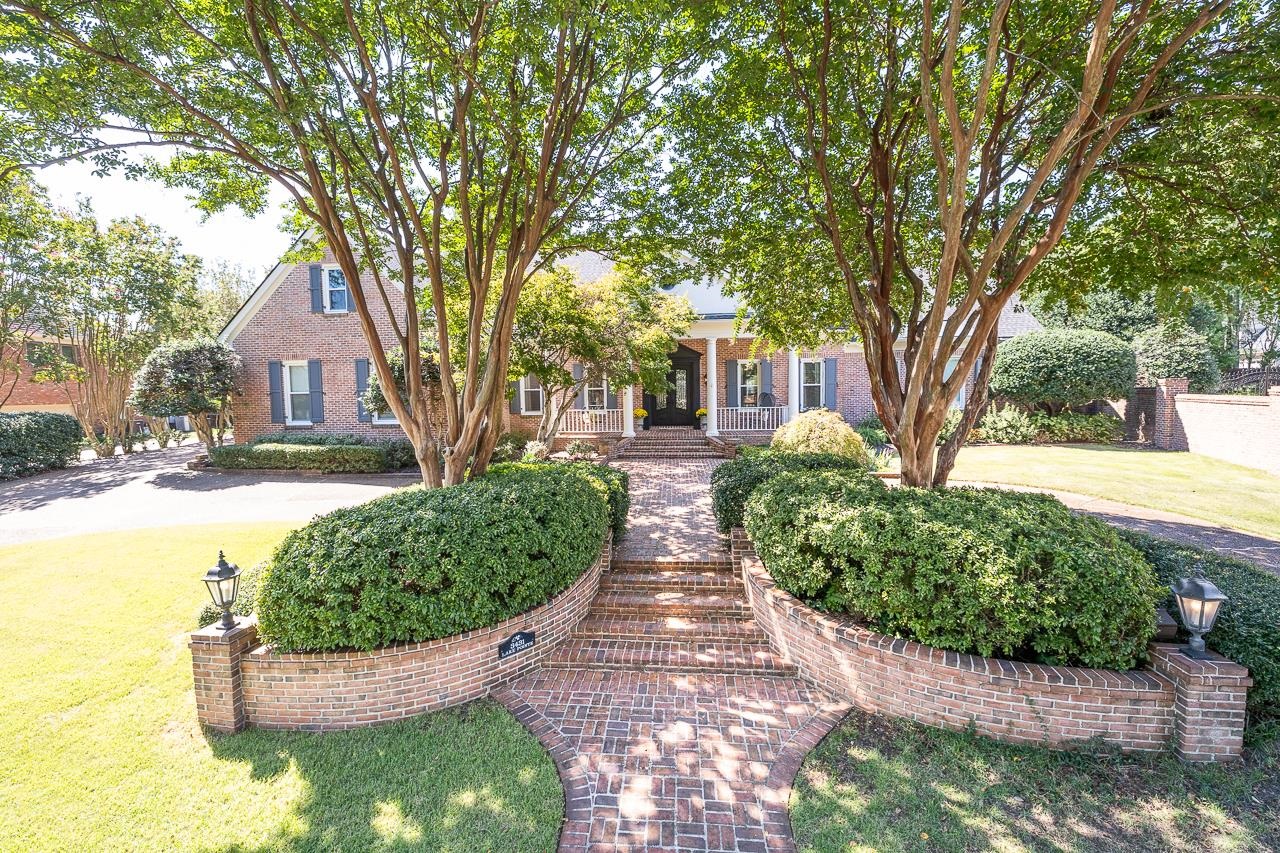 a front view of a house with a yard and potted plants