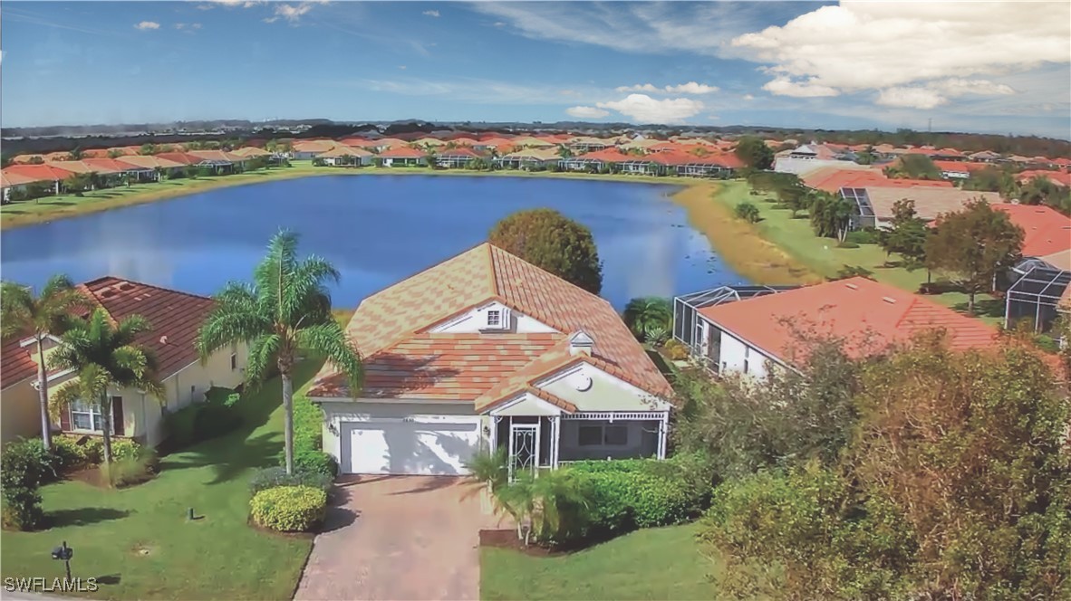 an aerial view of a house with a yard and lake view