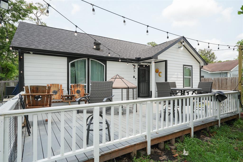 a view of a house with wooden deck and furniture