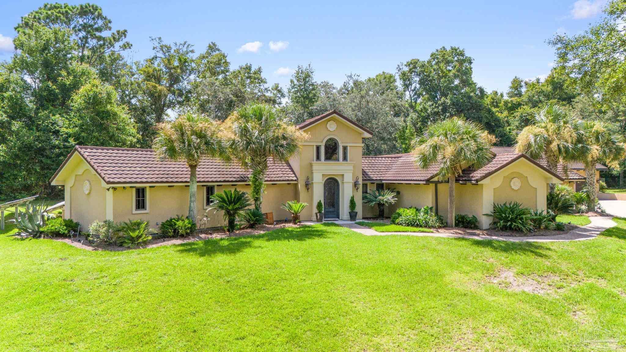 a front view of a house with a yard and trees