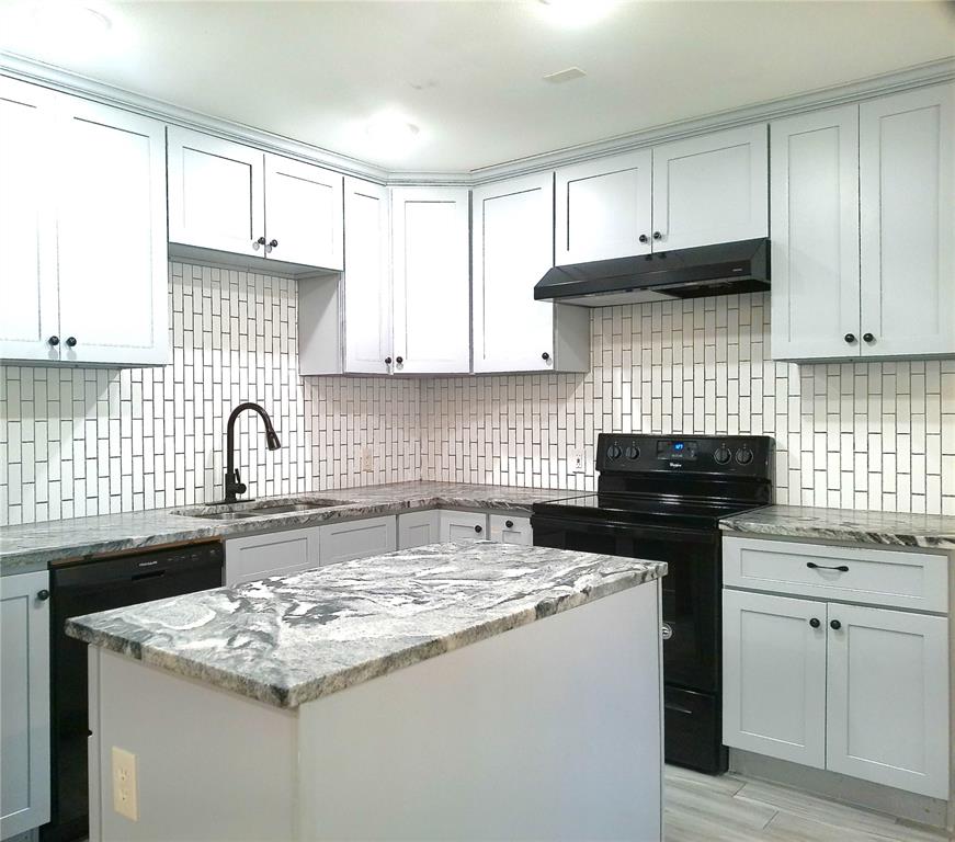 a kitchen with kitchen island granite countertop a sink a stove and cabinets