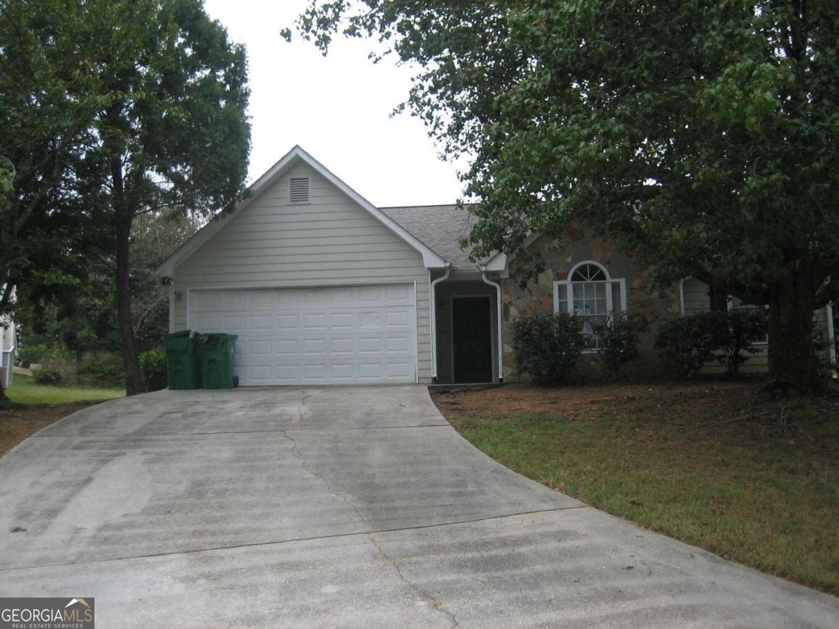 a front view of a house with yard and trees