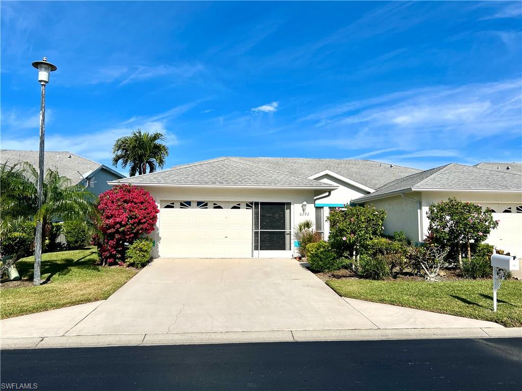 Single story home featuring a garage and a front lawn