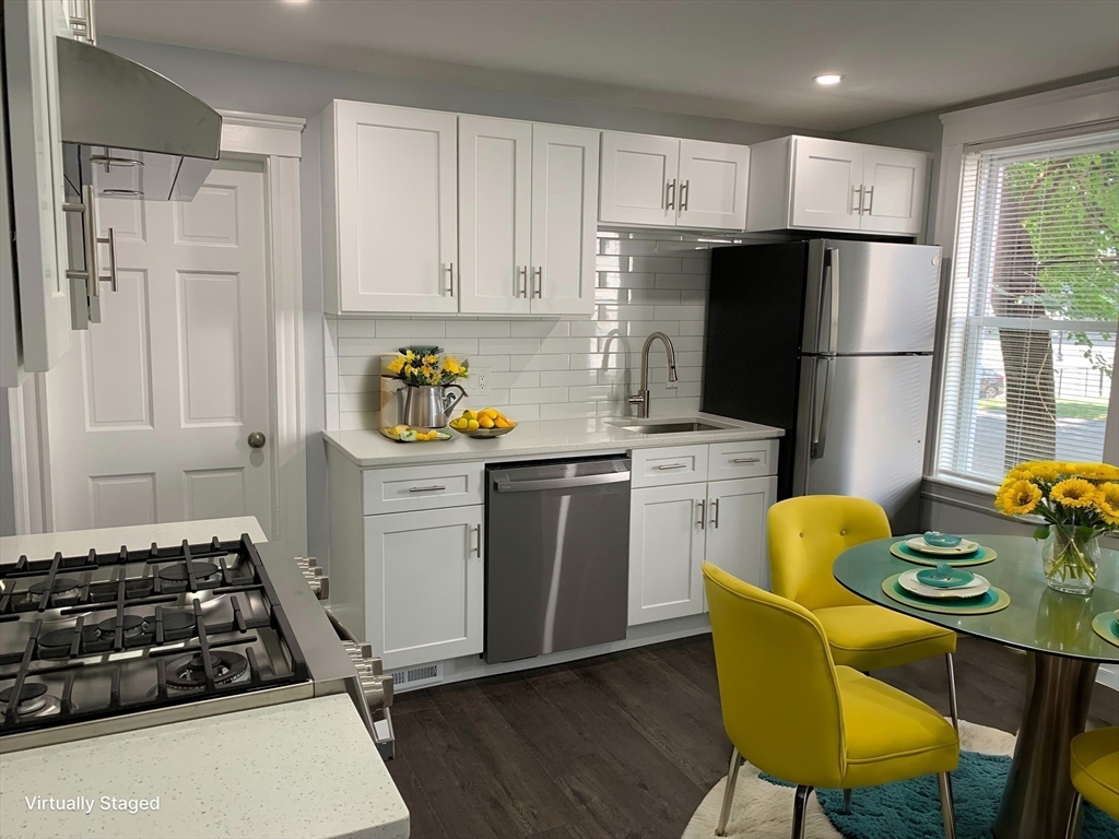 a kitchen with a refrigerator and a stove top oven