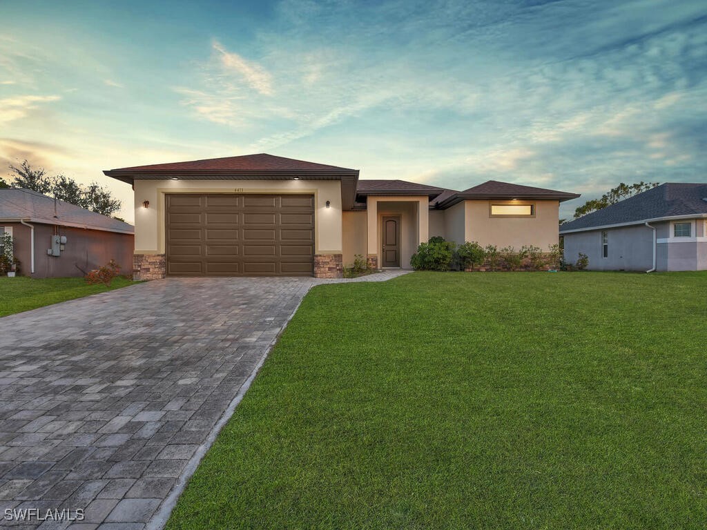 a front view of a house with a yard and garage