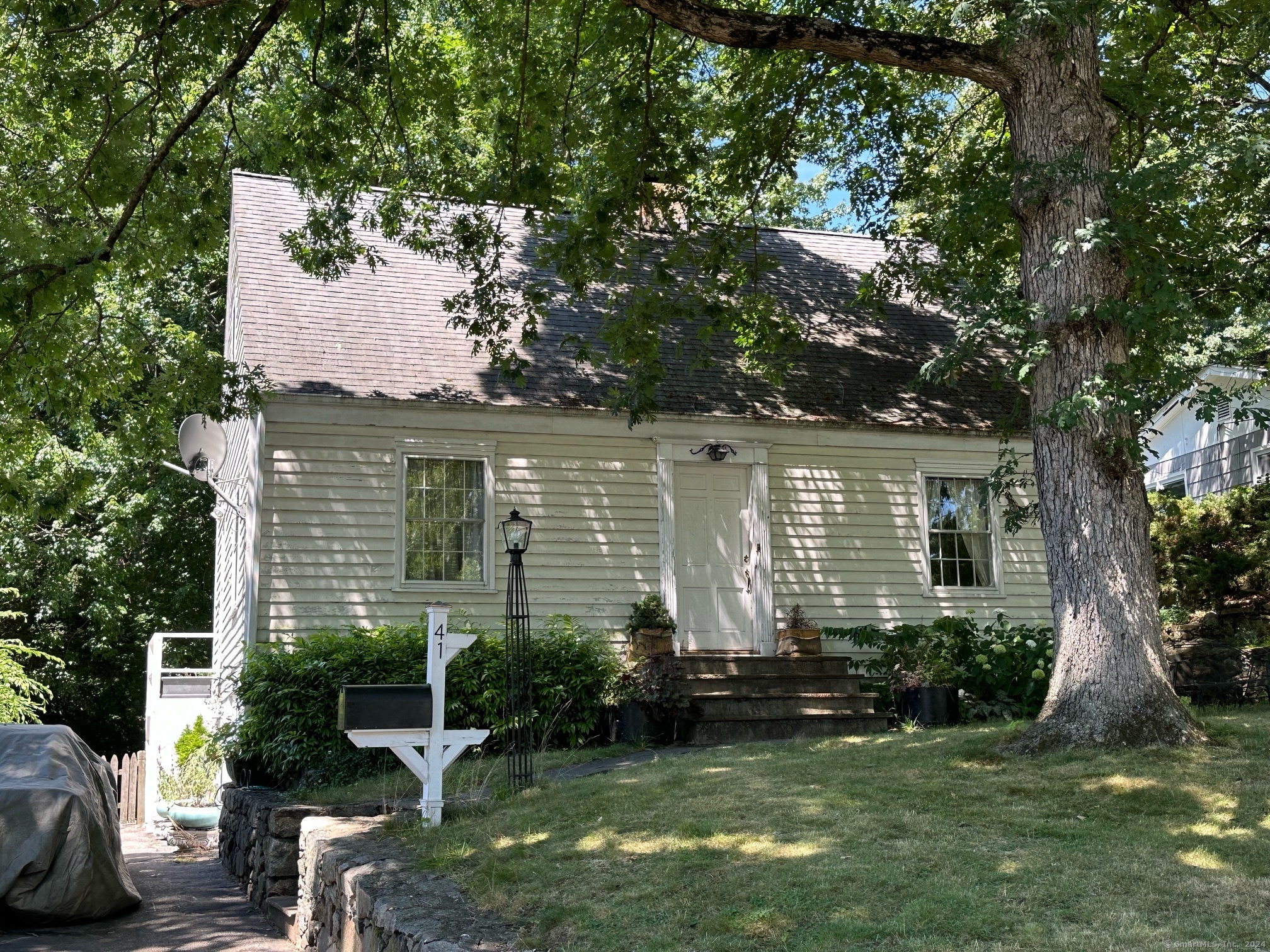 a front view of a house with a yard and potted plants