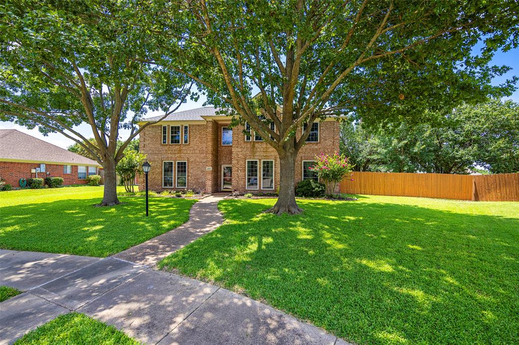 a front view of a house with a yard and trees