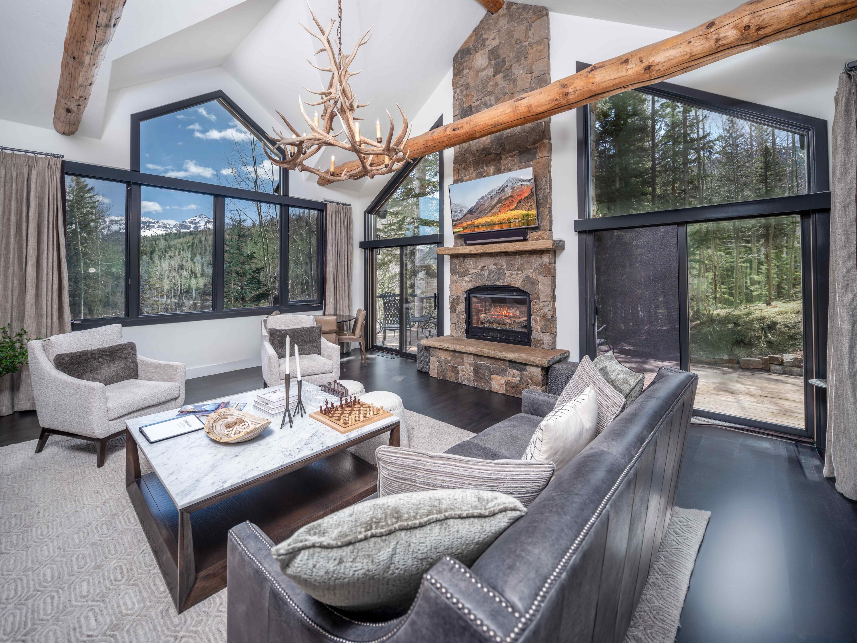 a living room with furniture a fireplace and a floor to ceiling window