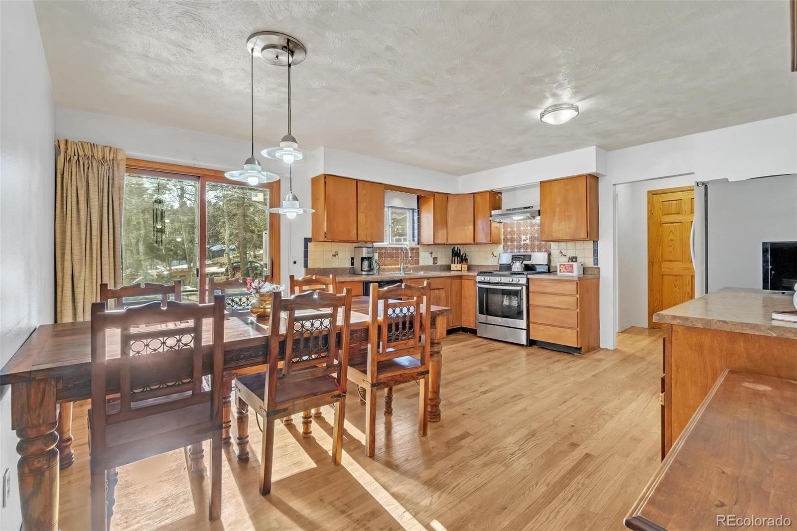 a view of a dining room and livingroom with furniture wooden floor a chandelier