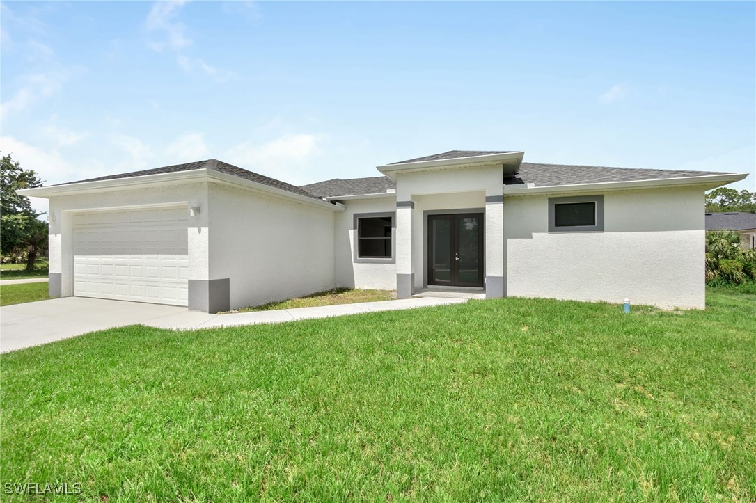 a front view of house with yard and garage