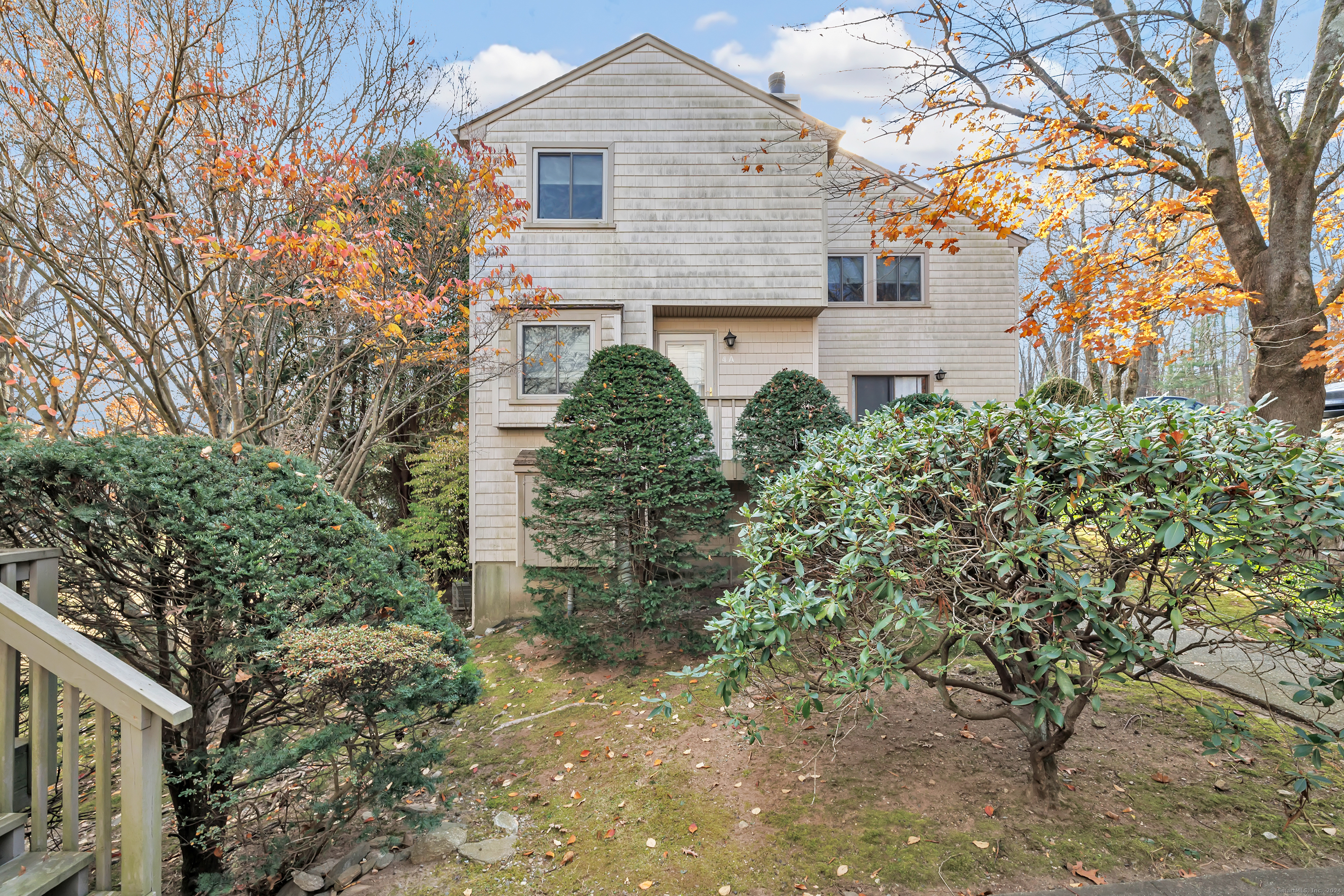 a front view of a house with plants and trees