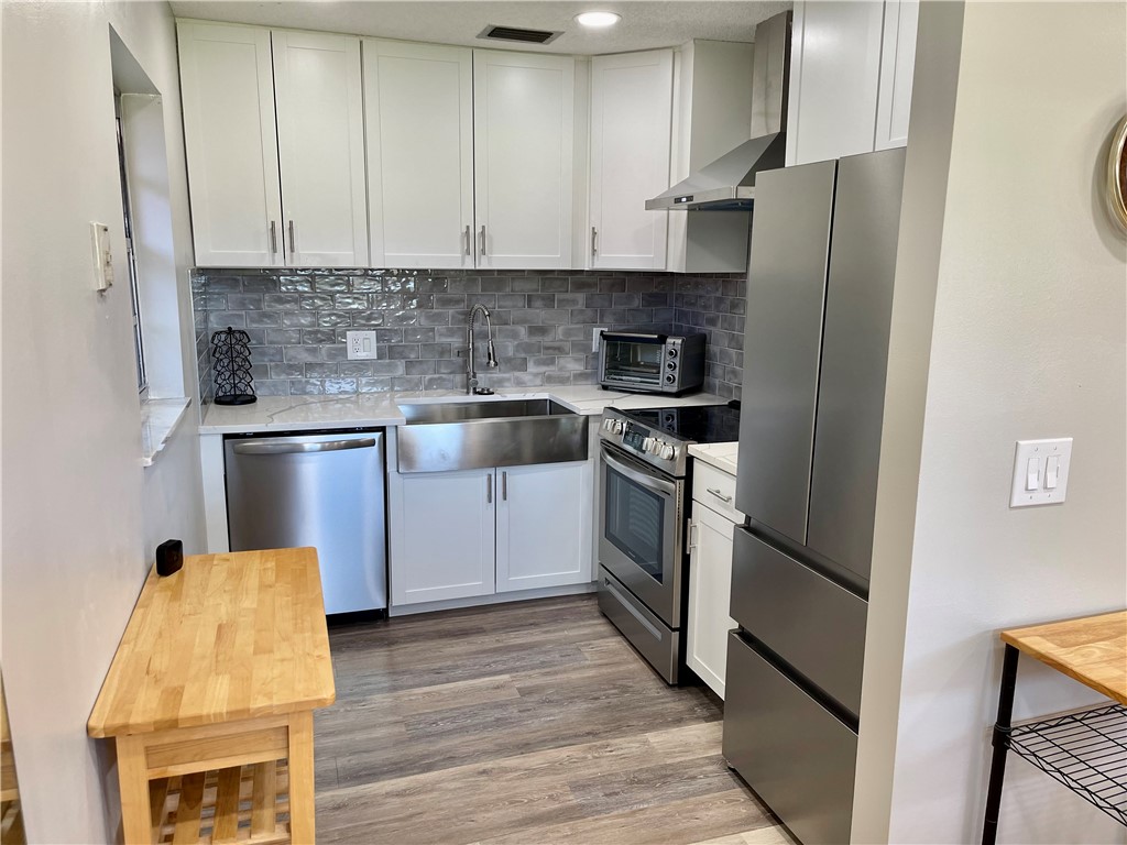 a kitchen with stainless steel appliances granite countertop a refrigerator sink and cabinets