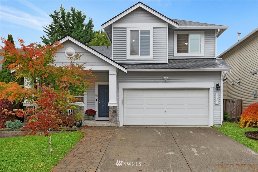 a front view of a house with a garden and garage