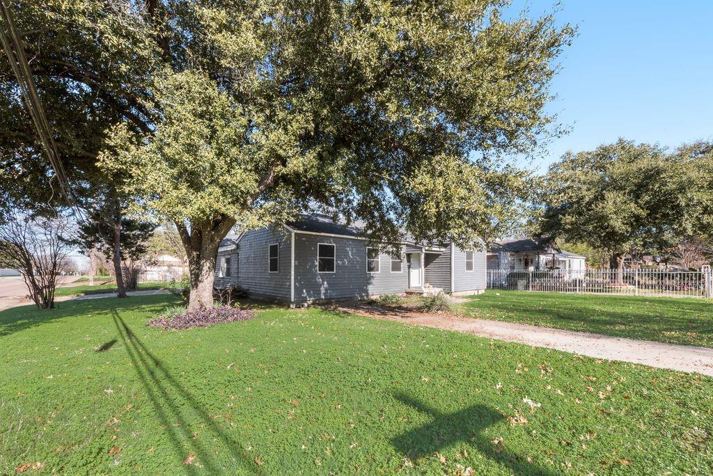 a front view of a house with a yard and trees