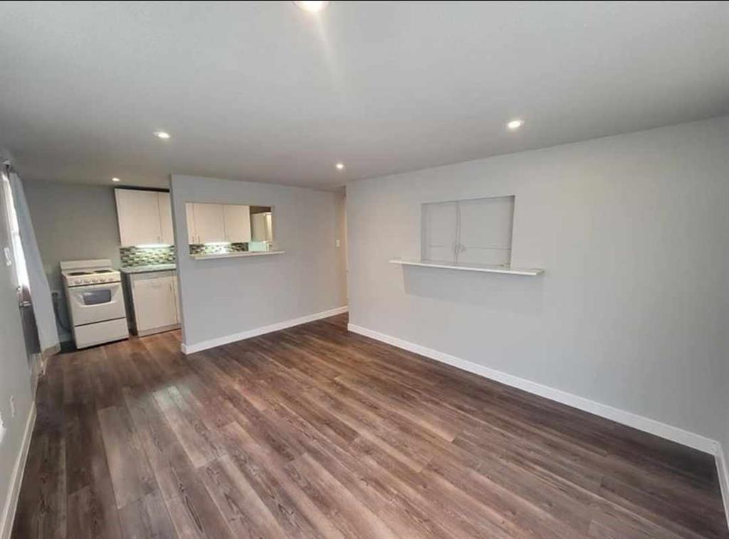 a view of a kitchen with wooden floor and electronic appliances