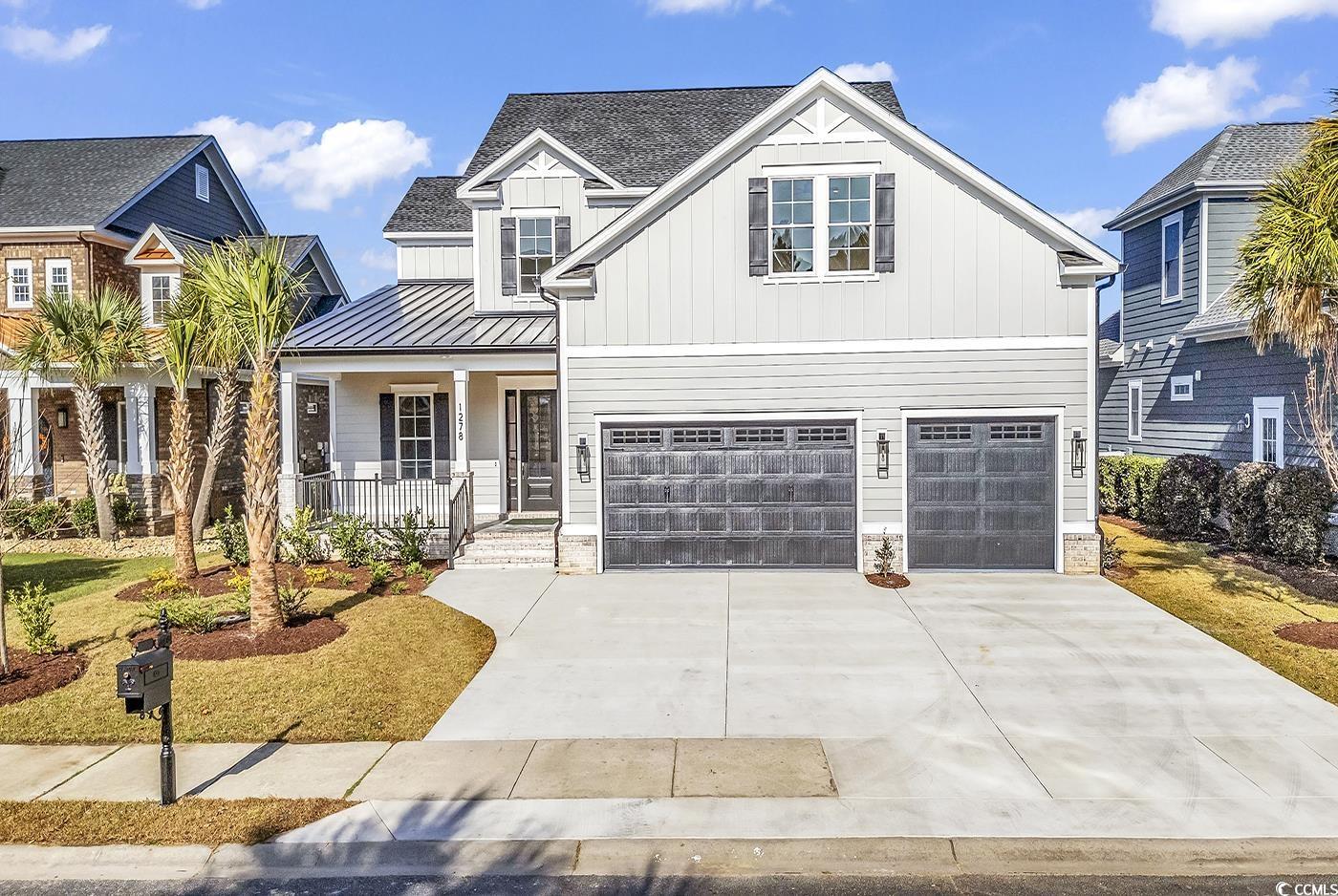 View of front of home featuring a garage and a por